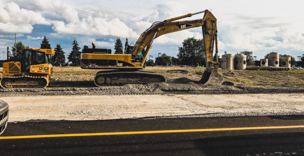 Temperatures soaring high on a construction site with sun beating down on heavy equipment like excavators and bulldozers