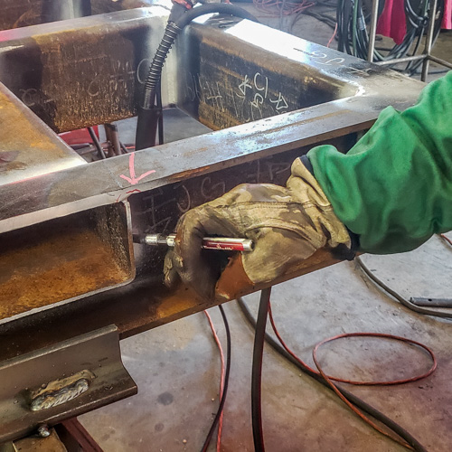 Welder using a tempil stik temperature indicating crayon, or temp stick, to verify base metal is above minimum specified preheat temperature prior to performing a repair weld.