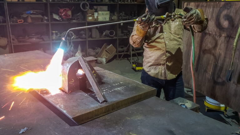 Welding using a rosebud torch to achieve minimum specified preheat temperature.
